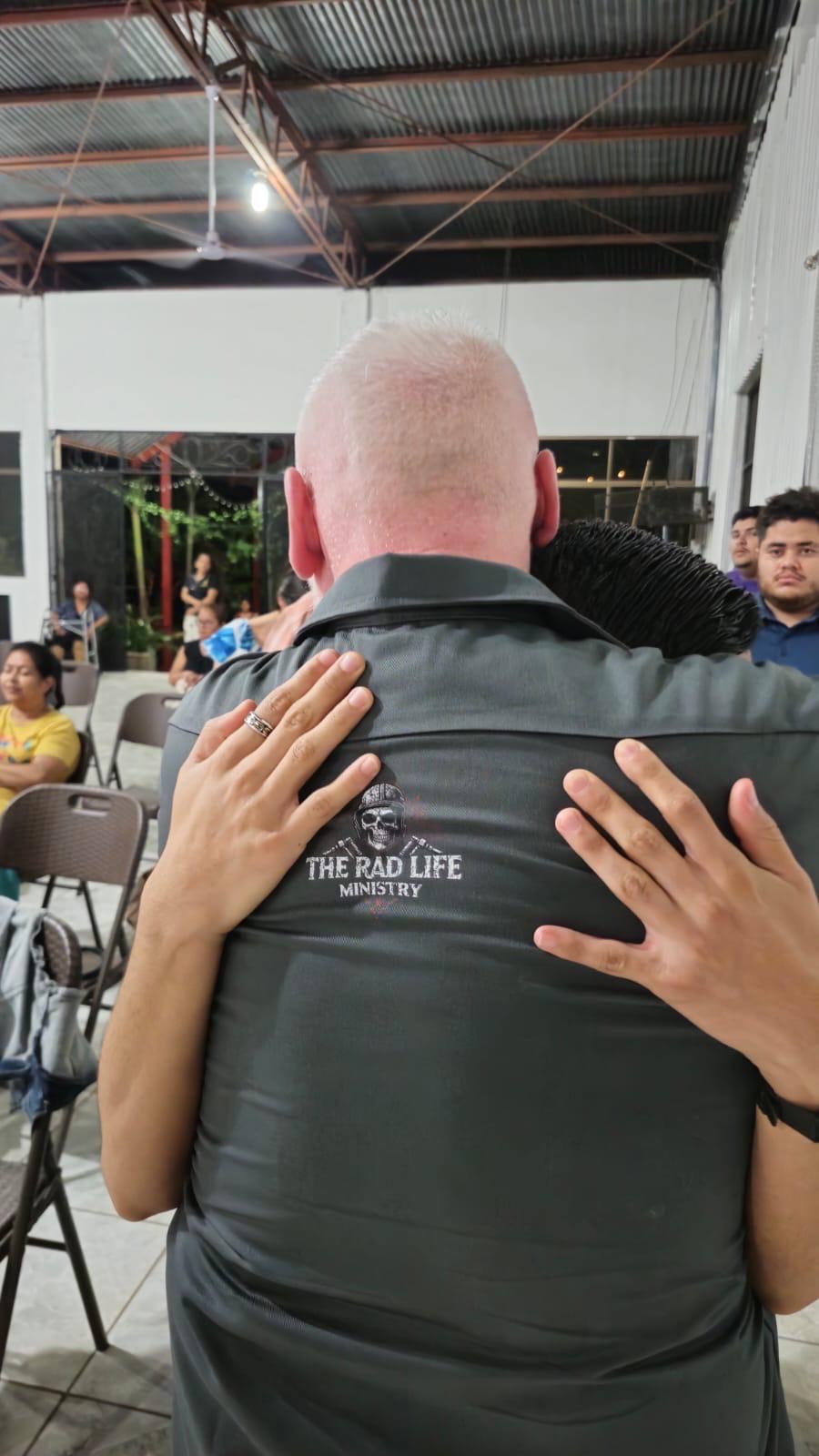 A person embracing Pastor Michael Chamberlain during prayer